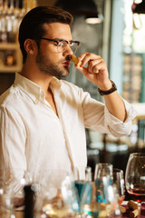 Elite alcohol. Smart nice man holding a wine bottle cork while checking its smell