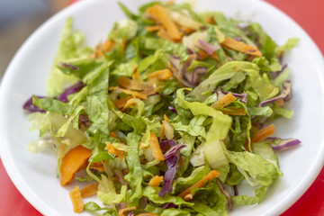 Close-up top shoot of fresh vegetable salad on the white plate