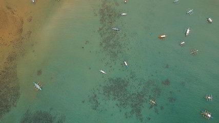 Fototapeta premium Aerial view of sailing boats and yachts in the bay. Boat and yacht in the tropical lagoon. Aerial view: tropical landscape. Philippines, El Nido. Travel concept.