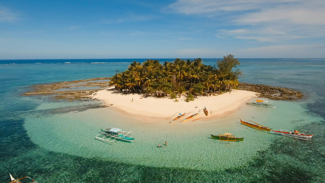 Aerial view of beautiful tropical island Guyam with white sand beach. View of a nice tropical beach from the air. Seascape: Ocean and beautiful beach paradise. Philippines. 4K video. Travel concept