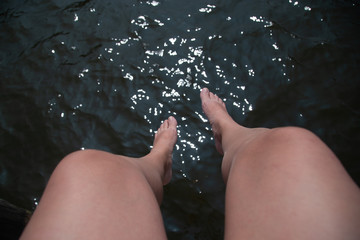 Legs hanging next to the water