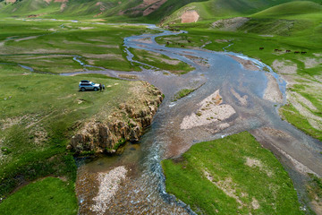 tourists on a car on a mountain river, top view