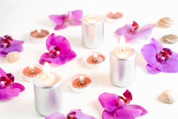 Fototapeta na wymiar Burning candles and orchid flowers on wooden background. Relaxation spa concept