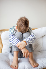 Unhappy boy covering his face 