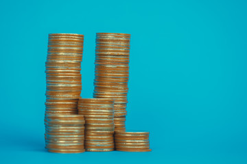 Columns of coins, piles of coins on blue background, business and financial concept.