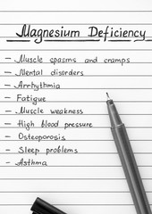 Symptoms of Magnesium Deficiency writing on the list with black pen.