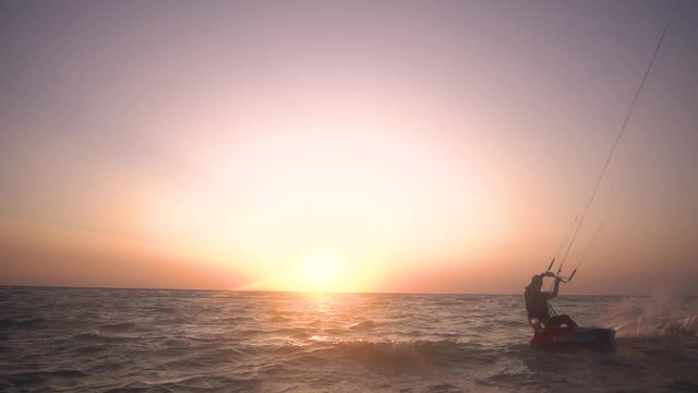 Slow-motion shooting, the man performs tricks and flies into the air against the dawn
