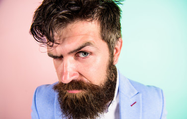 Man bearded hipster on strict face pink blue background. Barber tips grooming beard. Hipster guy with messy tousled hair and long beard needs barber service. Keep hair tidy and care about hairstyle