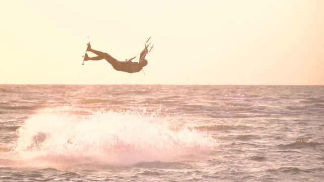 A man does a somersault in the air and falls into the water