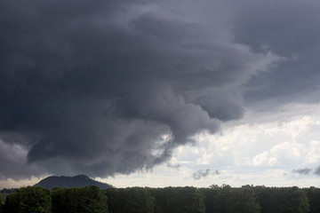 Heavy clouds over hills behind fruit trees on the Atherton Tableland in Queensland, Australia