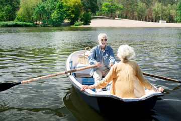 Fototapeta na wymiar Bearded husband. Bearded elderly husband sitting in boat with beautiful wife while having very romantic date