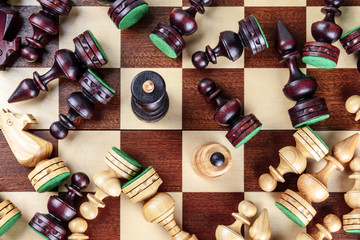 An overhead photo of a checkmate situation in chess with nearly all the pieces fallen on the chessboard