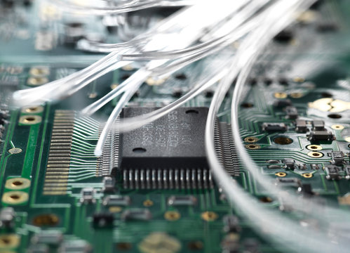 Fibre optics carrying data passing through a circuit board to illustrate artificial intelligence