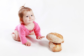 little girl is played with bread in the studio on a white background
