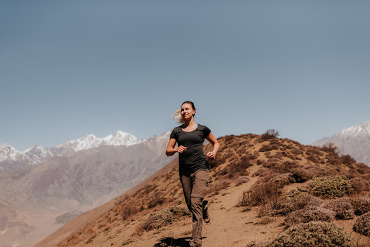 Woman jogging down from peak, Annapurna Circuit, the Himalayas, Muktinath, Nepal