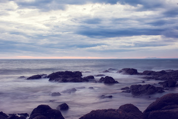 Fototapeta na wymiar View of a rocky coast at the sunset. Dramatic sea view before rain