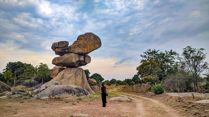 A balancing rock with a woman , Epworth, Harare, Zimbabwe