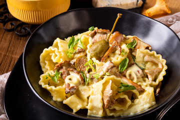 Reginette noodles in cream sauce with fresh chanterelles and capers