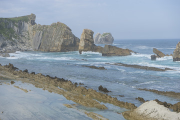 Rocks on the beach. Dramatic view of Playa de la Arnia, rocky coastline in Santander ,Cantabria, Spain.