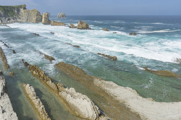 Touristic, Rocks on the beach. Dramatic view of Playa de la Arnia, rocky coastline in Santander ,Cantabria, Spain.