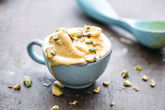 Homemade saffron ice cream with pistachio nuts, melting