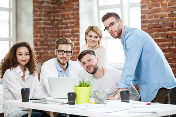 Group of young multiracial people working in modern light office. Businessmen at work during meeting.