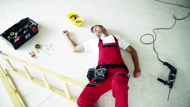 An unconscious man worker lying on the floor after accident on the construction site.