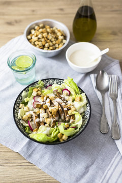 Bowl of Caesar salad with meat and red radish
