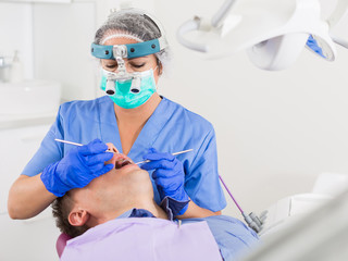 dentist professional filling teeth for man
