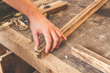 Carpenter examining quality fn the old wooden frame.