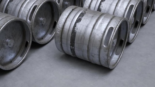 Multiple metal beer kegs being rolled on the ground in endless, seamless loop.
