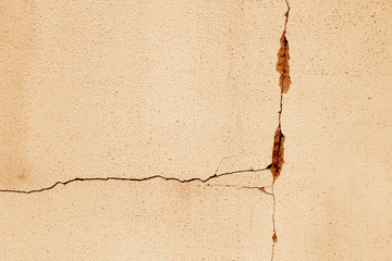 Cracked cement wall in orange tone.