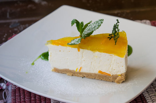 A Cake With A Yellow Top On A Plate With Green Syrup.