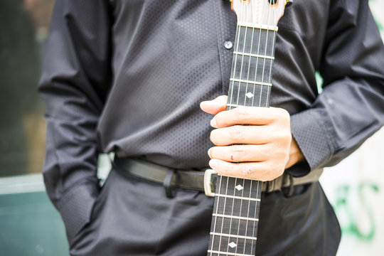 Musician holding his acoustic guitar outdoor