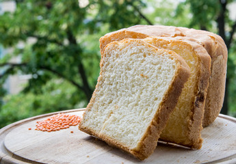White homemade bread on a background of green trees.