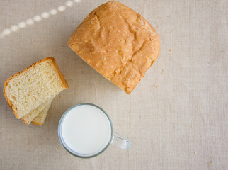 A glass of milk and pieces of white bread.