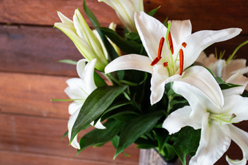 Fresh white flowers in a vase on a wooden floor...