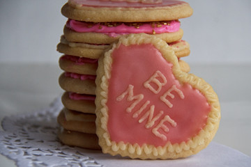 Stack of Frosted Heart Shaped Sugars Cookies That Say Be Mine