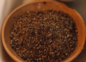 Ground black Peppercorns on old wooden table. Peppercorn Varieties. Milled black pepper. Black pepper corns and Black pepper Powder on wooden background. Close up, soft focus.