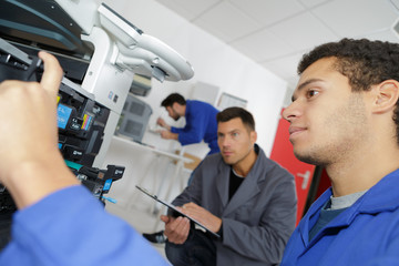 Fototapeta na wymiar young male technician repairing digital photocopier machine