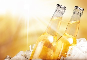 Bottles of beer in ice on blurred background