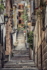 Old street with stairs in Granada in Spain. - obrazy, fototapety, plakaty