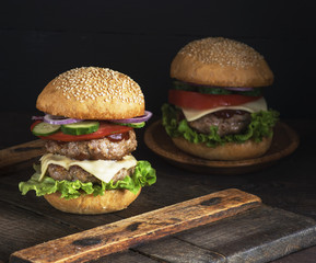 large burger with two fried cutlets, cheese and vegetables