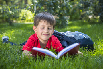 Cute smiling child boy read book.