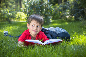 Cute smiling child boy read book.
