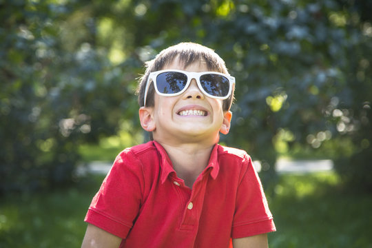 Happy smiling  child boy in sunglasses playing outdoor.