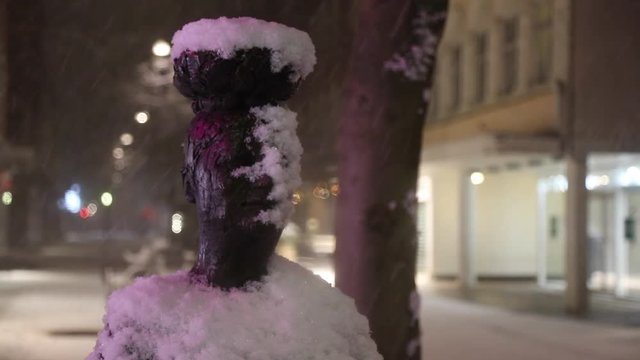 Snow falling on statue of The Woman With The Eggs