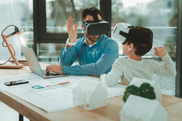 Great job. Happy nice father and son wearing 3d glasses while giving each other high five