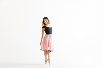 Ballerina Standing On Tiptoes While Rehearsing Over White Background