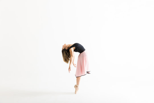 Side View Of Female Dancer Posing While Performing Ballet Dance